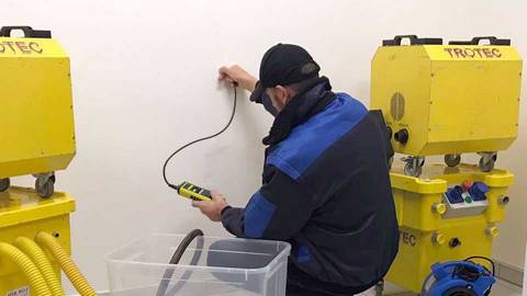 Techniker misst den Durchfeuchtungsgrad einer Wand mit einem Messgerät