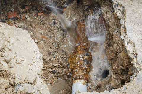 In der Wand geöffnete, beschädigte Wasserleitung