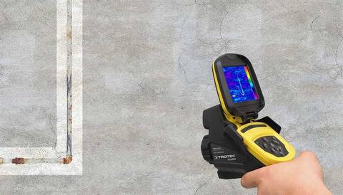 Techniker mit Wärmebildkamera untersucht feuchte Wand auf Leckage